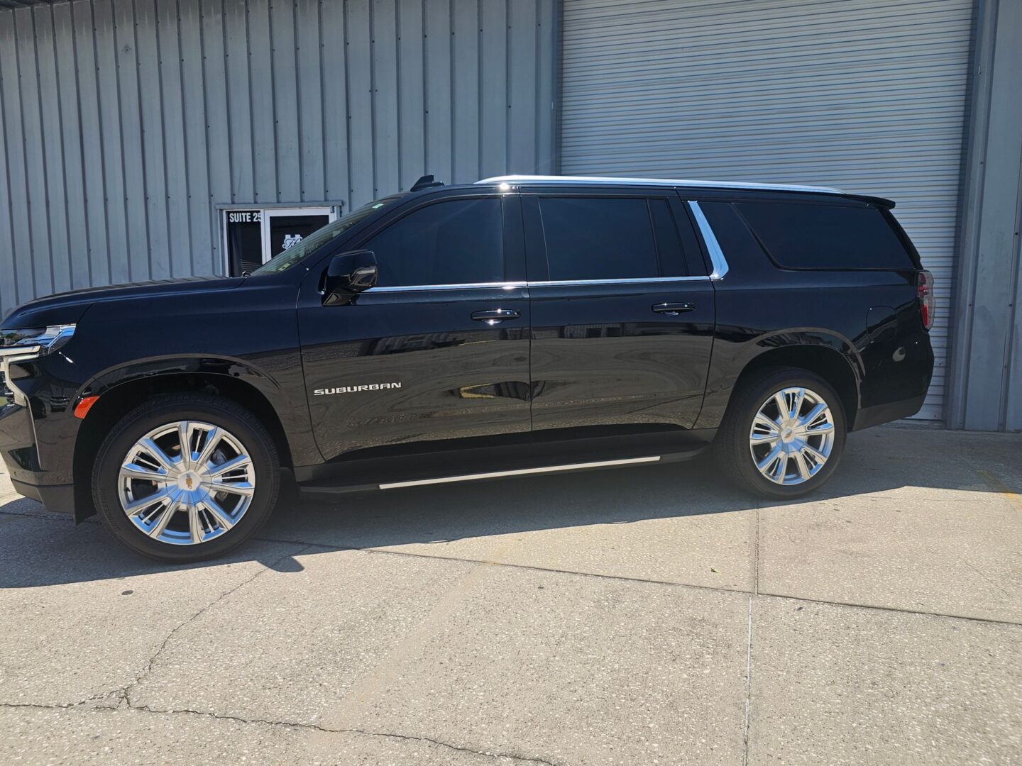 Shiny black SUV with chrome wheels.
