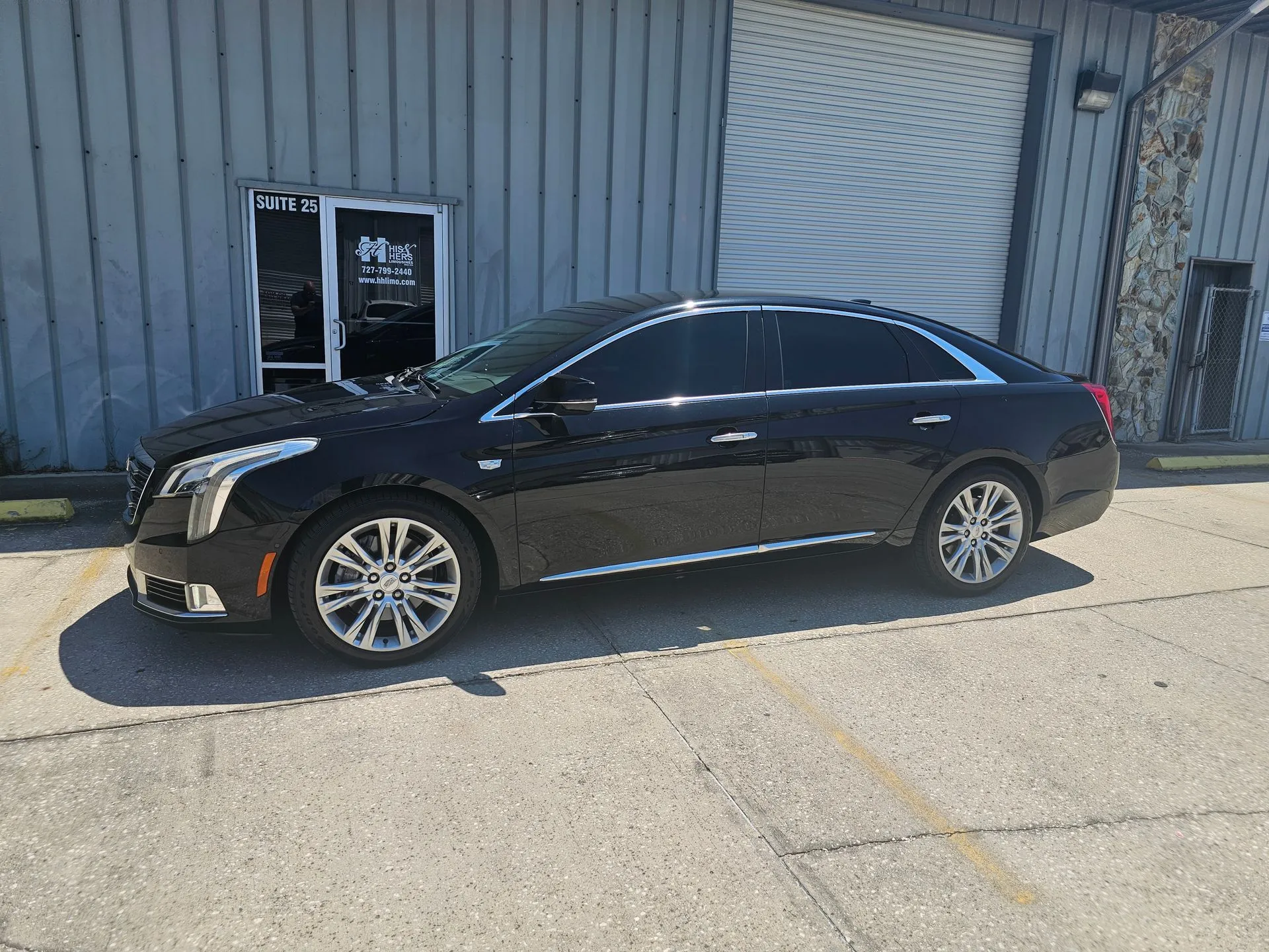 Black luxury sedan parked outside building