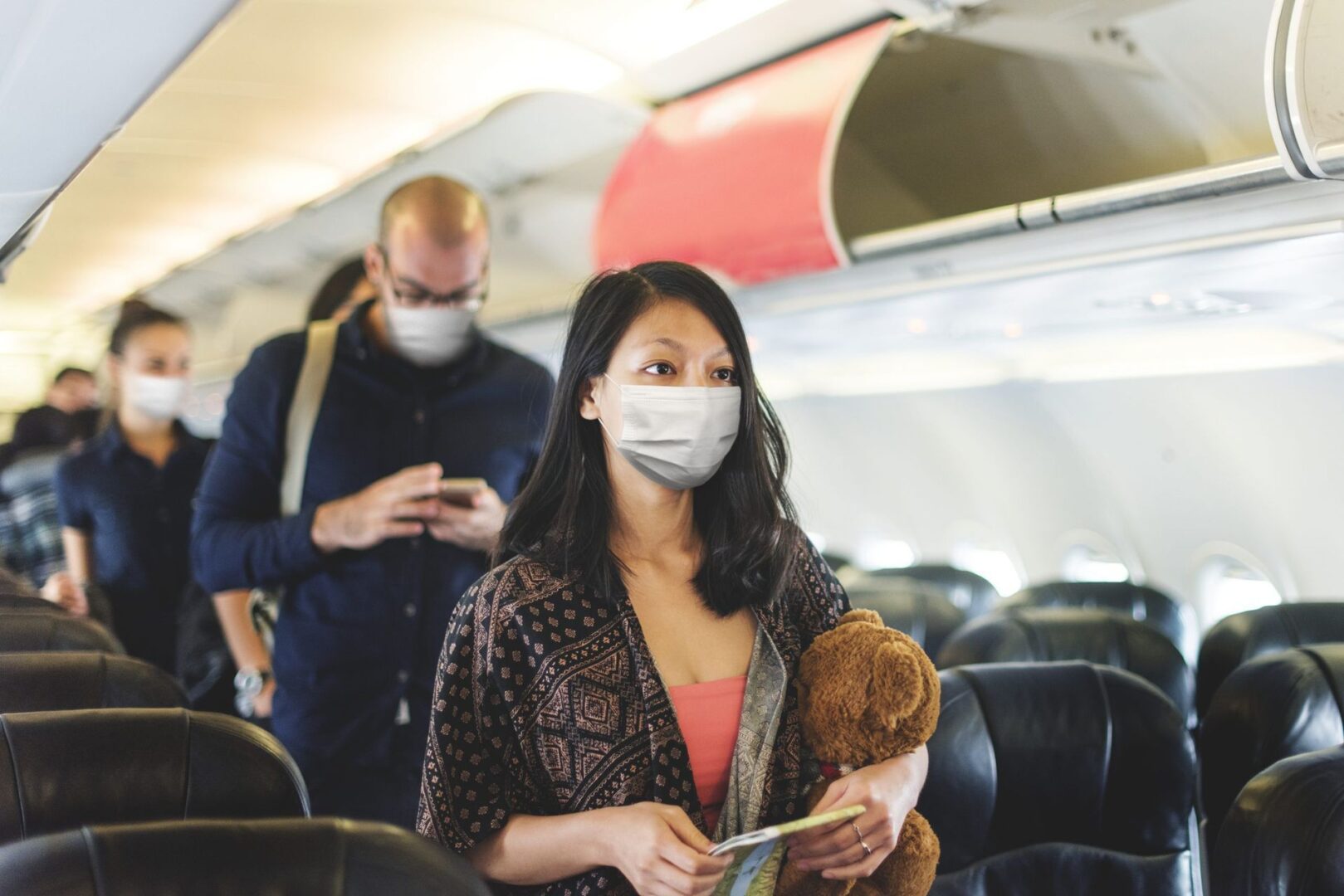 Woman holding teddy bear on plane