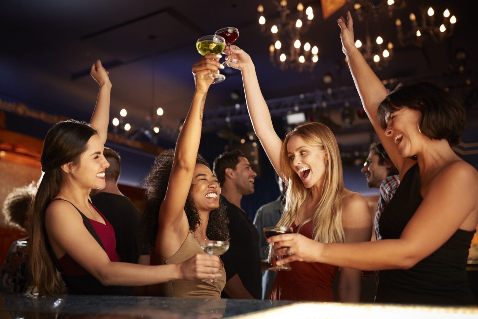 Women cheering with cocktails in nightclub