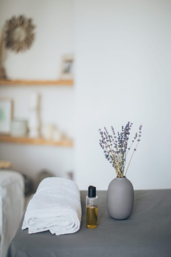 Cozy spa decor with lavender vase.