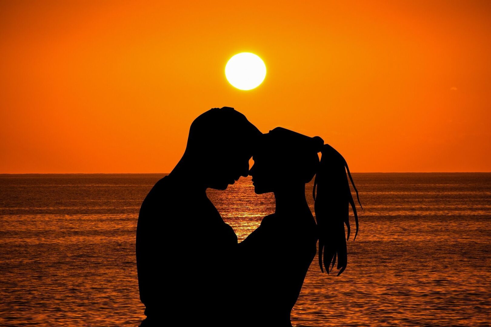 Couple embracing at sunset beach