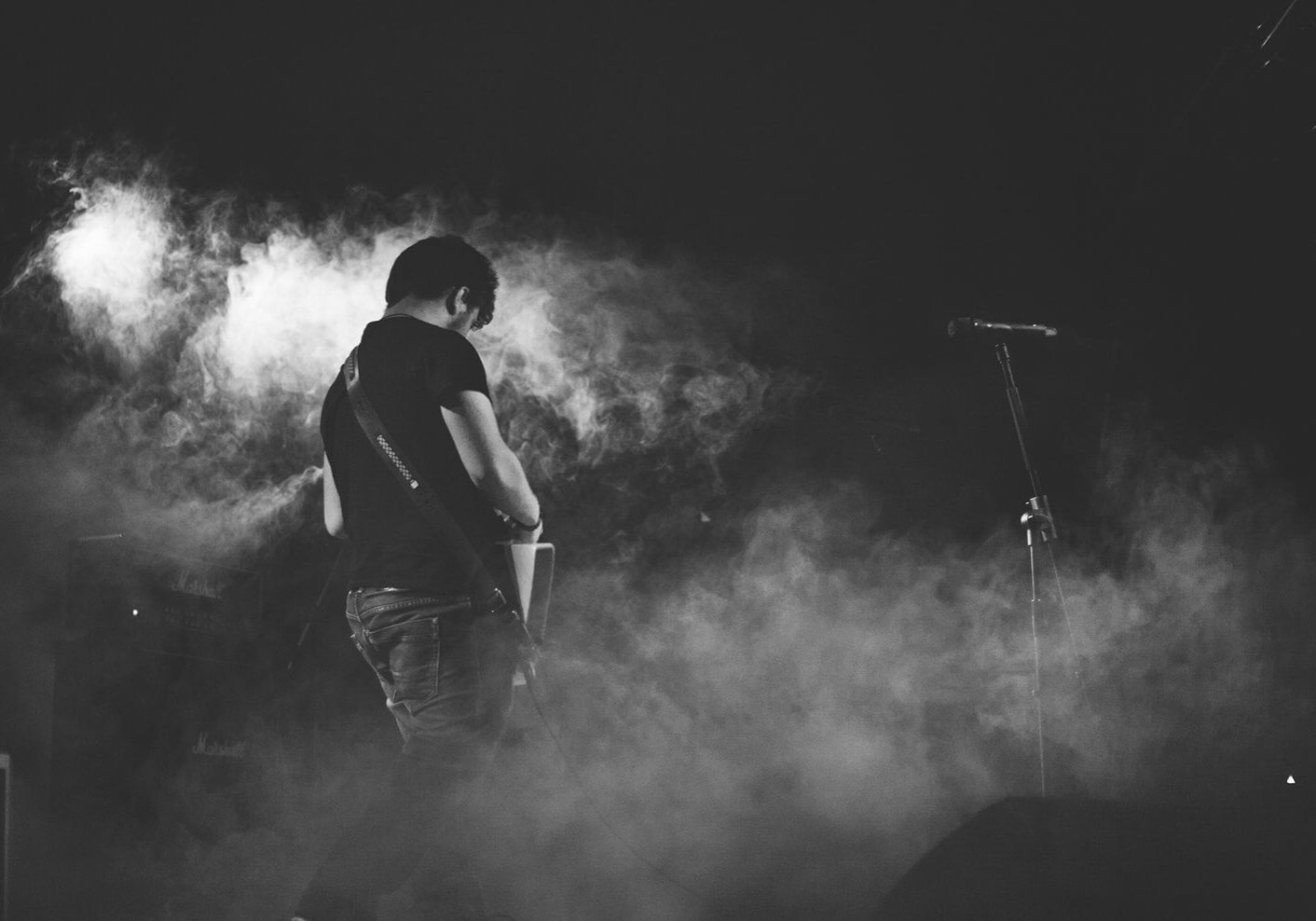 Guitarist performing on stage in smoke