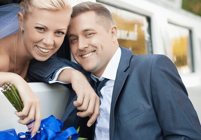Newlyweds posing with blue flowers