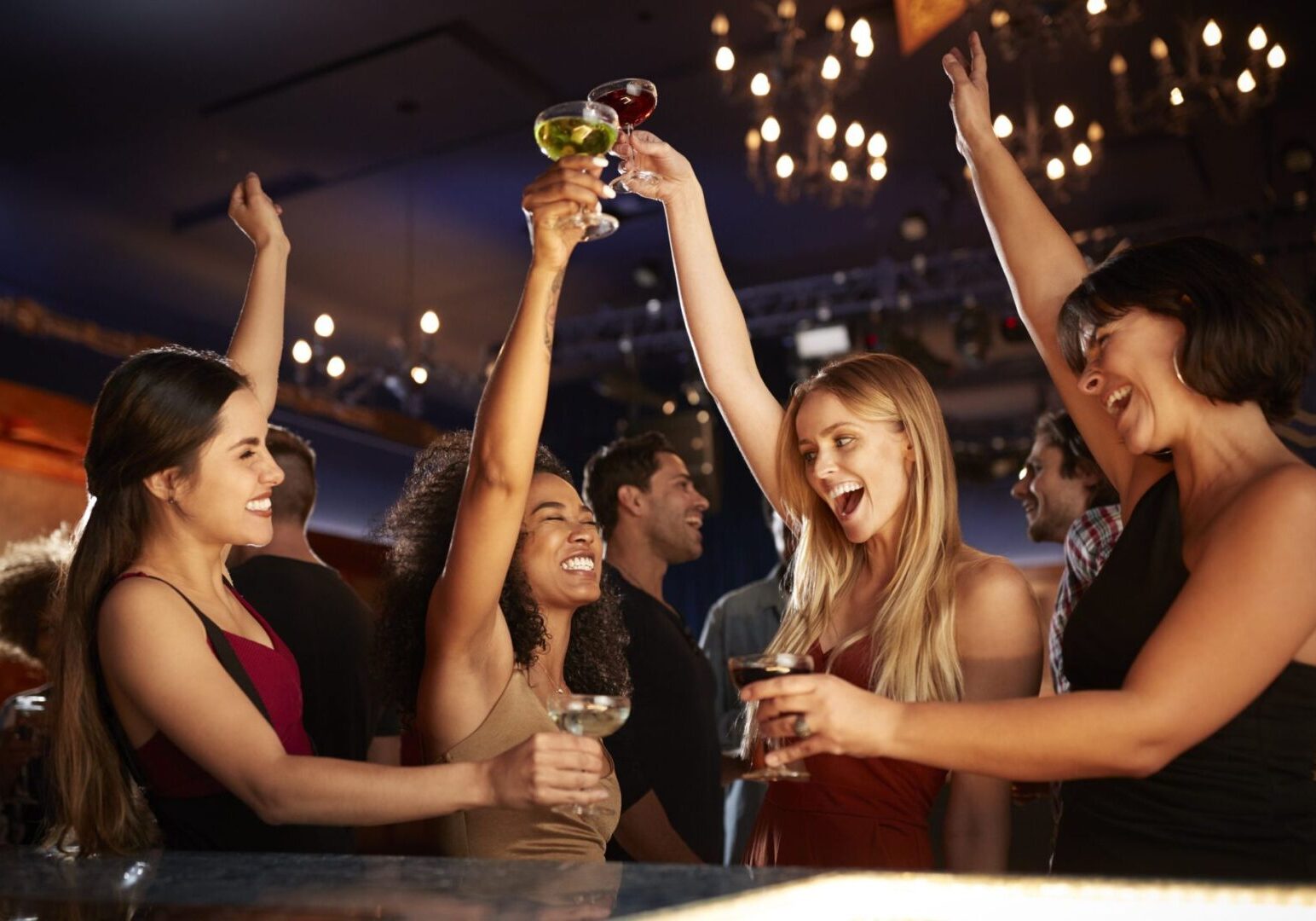 Women cheering with cocktails in nightclub